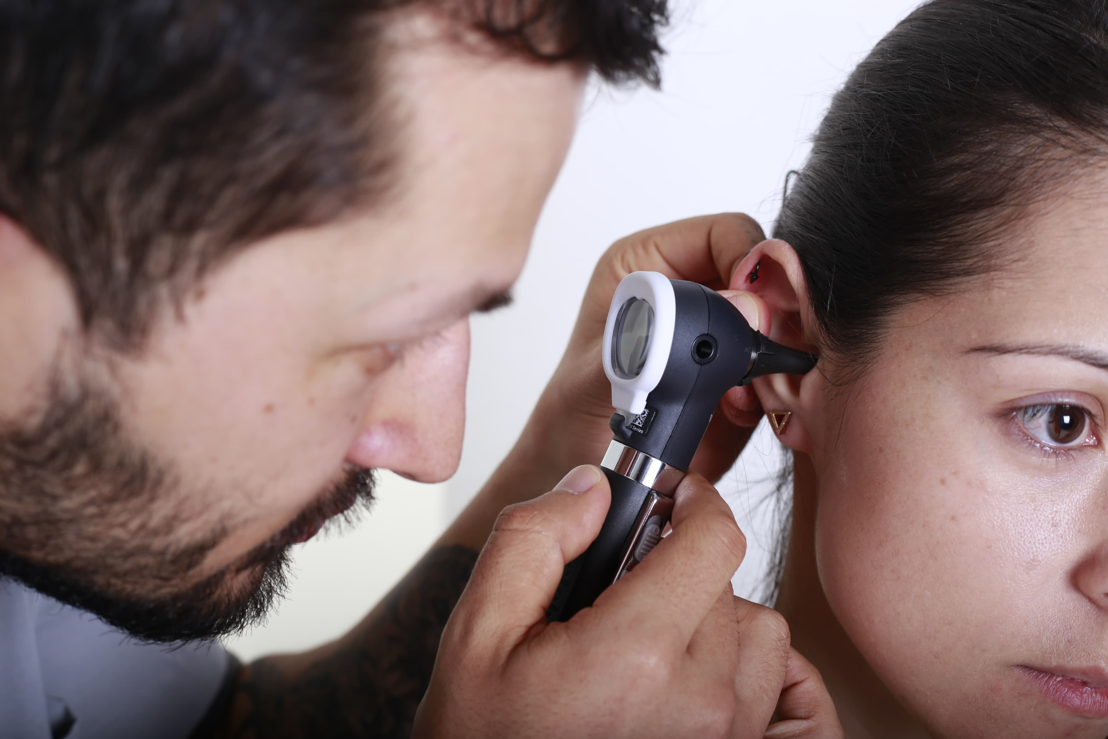 Evaluación auditiva con otoscopio durante consulta fonoaudiológica