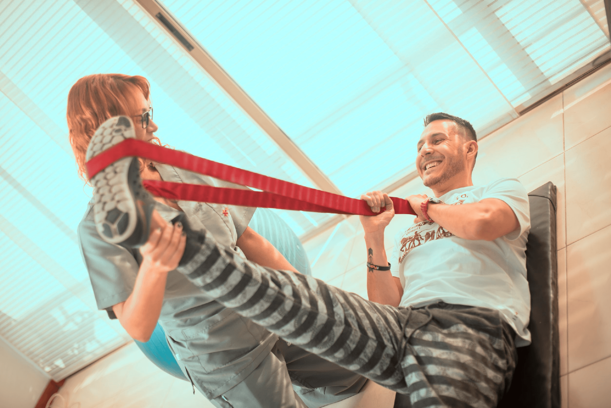 Sesión de fortalecimiento con banda elástica en terapia física domiciliaria